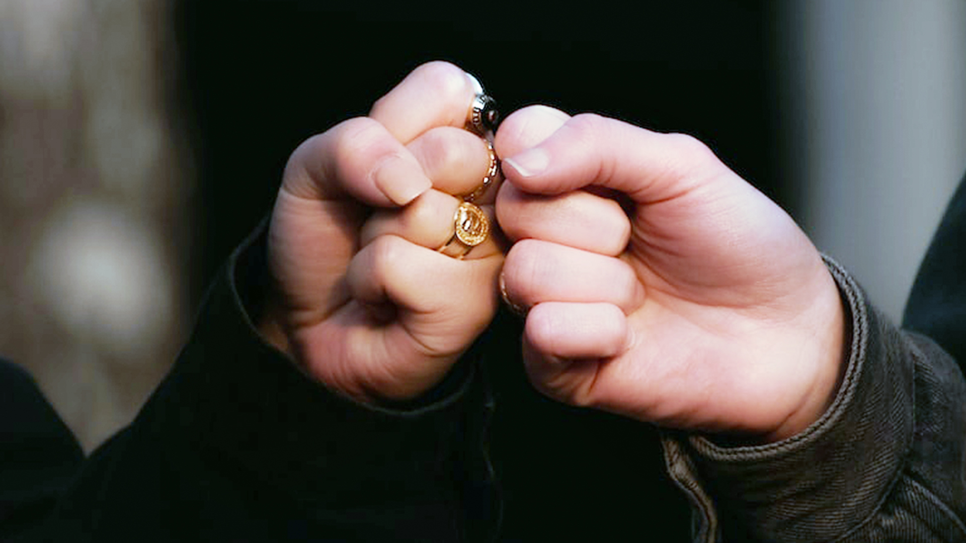 person holding gold ring in dark room